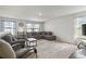 Bright living room with comfortable seating, large windows, and a patterned rug, creating a cozy and inviting atmosphere at 7037 Grant St., Little River, SC 29566