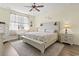 Comfortable main bedroom with a ceiling fan, neutral decor, and a large window offering natural light and a calming atmosphere at 7037 Grant St., Little River, SC 29566