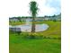 Scenic view of a community pond with a fountain, framed by lush green grass and colorful flowers at 7037 Grant St., Little River, SC 29566