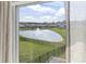 Window view of the community pond with fountain over the backyard and black aluminum fencing at 7037 Grant St., Little River, SC 29566