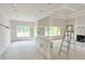 A spacious living room features a ladder, large windows, and a tray ceiling under construction at 804 Edisto Ct., Myrtle Beach, SC 29588