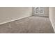 A bright bedroom features neutral carpet and a window for natural light at 1545 Spinnaker Dr. # 2C, North Myrtle Beach, SC 29582