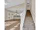 Bright living room with hardwood floors, a white staircase, and a view of the adjacent kitchen at 1545 Spinnaker Dr. # 2C, North Myrtle Beach, SC 29582
