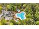 Aerial view of a community pool and clubhouse surrounded by lush trees and landscaping at 1545 Spinnaker Dr. # 2C, North Myrtle Beach, SC 29582