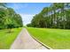 Beautiful golf course view with a lush green fairway, sidewalk and mature trees under a clear blue sky at 232 Marbella Dr., Murrells Inlet, SC 29576