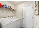 Bright laundry room features modern washer and dryer, with shelving for convenient storage of detergents and cleaning supplies at 232 Marbella Dr., Murrells Inlet, SC 29576