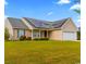 Charming home featuring solar panels, a manicured lawn, and a two-car garage at 601 Seth Ln., Longs, SC 29568