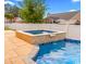 A luxurious pool with a spa featuring stone accents, complemented by a spacious deck ideal for entertaining and relaxation at 601 Seth Ln., Longs, SC 29568