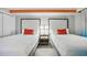 A bedroom featuring two twin beds with white linens and red pillows at 7200 N Ocean Blvd. # 1053, Myrtle Beach, SC 29572