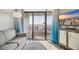 Cozy living room with TV and a view of the ocean from the balcony at 7200 N Ocean Blvd. # 1053, Myrtle Beach, SC 29572