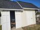 The building's exterior features a storage area, white doors, asphalt shingles and a garden at 7473 Louisville Rd., Aynor, SC 29511