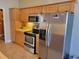 Kitchen features stainless steel appliances, oak cabinets and tile floors at 7473 Louisville Rd., Aynor, SC 29511