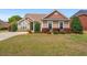 Charming single-story home with manicured lawn, complemented by mature trees and colorful landscaping at 826 Sand Binder Dr., Myrtle Beach, SC 29579