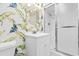 Stylish bathroom featuring a vibrant banana leaf wallpaper and a shower with sliding glass doors at 10100 Lakeshore Dr. # C-1, Myrtle Beach, SC 29572