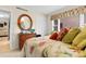 Cozy bedroom featuring a decorative round mirror, closet, and bed with floral patterned bedding at 10100 Lakeshore Dr. # C-1, Myrtle Beach, SC 29572