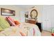 Comfortable bedroom with warm tones, floral bedding, a round mirror and a framed photo on the dresser at 10100 Lakeshore Dr. # C-1, Myrtle Beach, SC 29572