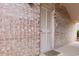 Exterior brick facade featuring a white door with slats and a small doorstep mat. There is a doorbell to the left at 10100 Lakeshore Dr. # C-1, Myrtle Beach, SC 29572