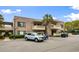 A two-story brick condo building featuring a palm tree and parked golf carts at 10100 Lakeshore Dr. # C-1, Myrtle Beach, SC 29572