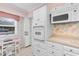Bright white kitchen with a full suite of appliances and charming wallpaper at 10100 Lakeshore Dr. # C-1, Myrtle Beach, SC 29572
