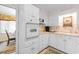 Bright white kitchen with a full suite of appliances and charming wallpaper at 10100 Lakeshore Dr. # C-1, Myrtle Beach, SC 29572