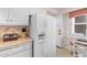 Bright, eat-in kitchen with white cabinets and appliances plus leafy wallpaper at 10100 Lakeshore Dr. # C-1, Myrtle Beach, SC 29572