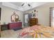 A bright bedroom featuring a ceiling fan, floral bedding, and ample dresser storage, offering a cozy retreat at 105 Windsor Springs Rd., Conway, SC 29526