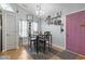 A dining area with modern table set, complemented by a charming purple door and bright window with hanging plants at 105 Windsor Springs Rd., Conway, SC 29526