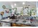 A cozy kitchen featuring a stainless steel sink, decorative lattice with greenery, and charming nautical-themed decor at 105 Windsor Springs Rd., Conway, SC 29526