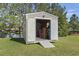 An outdoor shed with an open door and a ramp leading into the building, with the yard and pond in the background at 105 Windsor Springs Rd., Conway, SC 29526