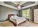 A bedroom with a tray ceiling, ceiling fan, and a large window with natural light at 109 Pheasant Run Dr., Murrells Inlet, SC 29576