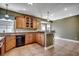 An open kitchen features wood cabinets, breakfast bar, tile flooring and modern lighting at 109 Pheasant Run Dr., Murrells Inlet, SC 29576