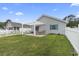A spacious backyard featuring a pergola, white picket fence, and lush green lawn at 1130 Ganton Way, Myrtle Beach, SC 29588