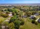An aerial view featuring a community surrounded by lush landscaping, mature trees, a tennis court, and distant waterfront views at 120 Wraggs Ferry Rd., Georgetown, SC 29440