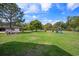 Lush backyard with mature trees, a spacious lawn, playset, and separate garage with chicken coop at 120 Wraggs Ferry Rd., Georgetown, SC 29440