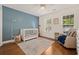 Charming Bedroom featuring a white crib, blue accent wall, and hardwood floors at 120 Wraggs Ferry Rd., Georgetown, SC 29440