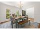 A dining room featuring a rustic table, wooden bench, blue chairs, and two large windows at 120 Wraggs Ferry Rd., Georgetown, SC 29440