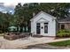 Exterior featuring a patio with umbrella-shaded tables adjacent to a charming building, enveloped by lush green foliage at 120 Wraggs Ferry Rd., Georgetown, SC 29440