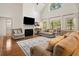 Bright living room features a fireplace, TV, soaring ceilings, and large windows at 120 Wraggs Ferry Rd., Georgetown, SC 29440