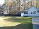 Spacious backyard with green lawn and a home in the background, partly shaded at 1208 Mackie Circle, Myrtle Beach, SC 29579