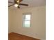 Cozy bedroom with light walls, wood flooring, window overlooking the outdoors and a ceiling fan for added comfort at 1208 Mackie Circle, Myrtle Beach, SC 29579