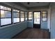 Inviting sunroom with light wood flooring and plentiful windows allowing for natural light and views of the surrounding landscape at 1208 Mackie Circle, Myrtle Beach, SC 29579