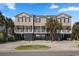 Inviting exterior elevation featuring tropical landscaping and stilt construction, ideal for coastal living at 1210 A S Ocean Blvd., Surfside Beach, SC 29575