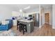Bright kitchen with white cabinets, stainless steel appliances, gray island, and wood-look flooring at 1210 A S Ocean Blvd., Surfside Beach, SC 29575
