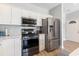 Detailed view of kitchen appliances including stainless steel refrigerator, oven, and microwave in well-lit area at 1210 A S Ocean Blvd., Surfside Beach, SC 29575