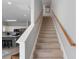 Carpeted staircase with wood railing leading to a home's upper level and open kitchen area at 1210 A S Ocean Blvd., Surfside Beach, SC 29575