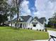 Beautifully landscaped new construction home featuring a covered porch, black framed windows, and a large yard at 1464 Hawthorn Dr., Pawleys Island, SC 29585