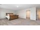 Bedroom showcasing a wooden bed frame, neutral carpet, and open doorway to walk-in closet at 147 Ashworth Dr., Tabor City, NC 28463