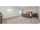 Spacious bedroom with neutral carpet, two windows, and wood furniture at 147 Ashworth Dr., Tabor City, NC 28463