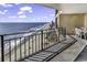 Spacious balcony shows oceanfront views, metal railings, and a table with chairs at 1690 N Waccamaw Dr. # 1008, Garden City Beach, SC 29576