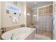 Bathroom with a glass enclosed shower and separate jacuzzi tub with beige tile surround at 2039 Woodburn Dr., Myrtle Beach, SC 29579